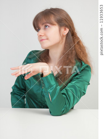 Coquettish beautiful girl sits at table Coquettish beautiful girl sits at table 11933653