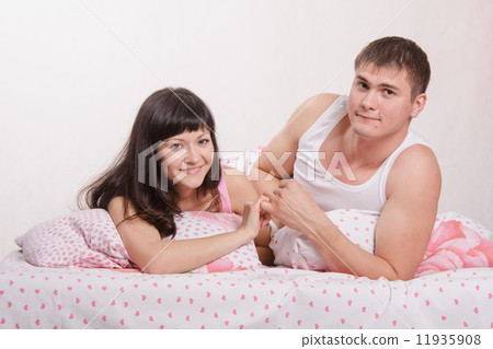 Young girl and the guy put up, lying in bed 11935908