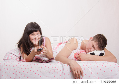 Wife watching TV series, while her husband sleeps football fan 11935966