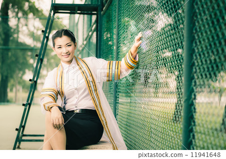 The female graduation portrait in academic gown is looking forwa The female graduation portrait in academic gown is looking forwa 11941648