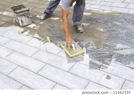 Grouting tiles on the floor 11942595