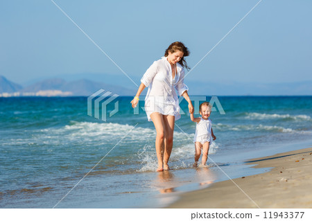 Mother and daughter running on the beach 11943377