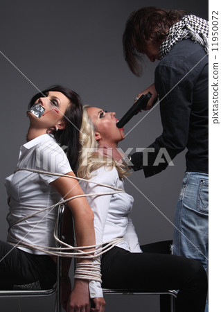 Crime. Two beautiful girls in the Business clothing kidnapped by criminals. Terrorist is threatening 11950072