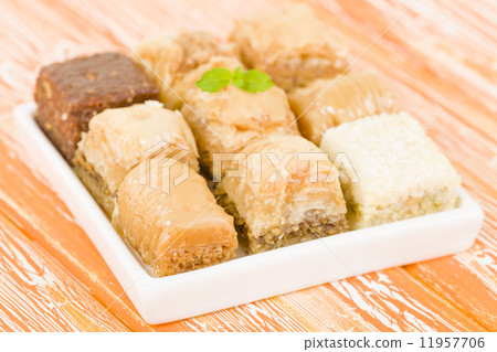Baklava - Middle Eastern sweet pastry and nuts selection on an orange background. 11957706