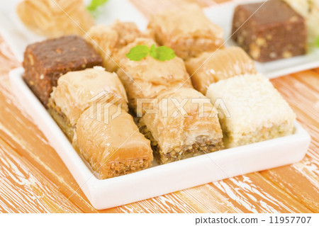 Baklava - Middle Eastern sweet pastry and nuts selection on an orange background. 11957707