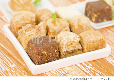 Baklava - Middle Eastern sweet pastry and nuts selection on an orange background. 11957710