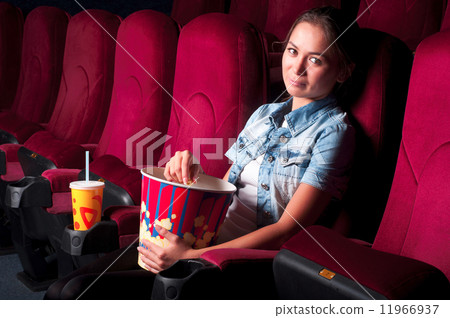 young attractive woman sitting in a cinema young attractive woman sitting in a cinema 11966937