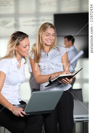 Smiling businesswomen in the office Smiling businesswomen in the office 11972434