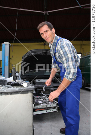 Man working in garage Man working in garage 11972756