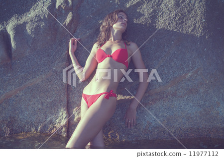 Young woman outdoor portrait on wild rocky seashore beach stone landscape sea view in red bikini swi Young woman outdoor portrait on wild rocky seashore beach stone landscape sea view in red bikini swi 11977112