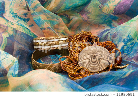 two bracelets and a necklace on a multicolored silk two bracelets and a necklace on a multicolored silk 11980691