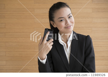 Asian Business Woman Indoor with mobile telephone Asian Business Woman Indoor with mobile telephone 11989326