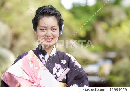 在手中戴著日本庭院和禮物的中間婦女 在手中戴著日本庭院和禮物的中間婦女 11991659