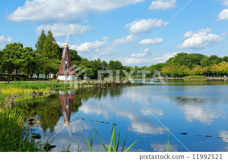 藍色的天空傳播的Ukima公園的風車和湖面反射的風景 藍色的天空傳播的Ukima公園的風車和湖面反射的風景 11992521