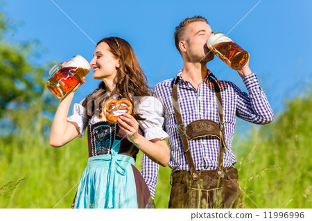 German couple in Tracht with beer and pretzel German couple in Tracht with beer and pretzel 11996996
