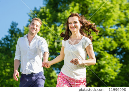 Couple in love running through park Couple in love running through park 11996998