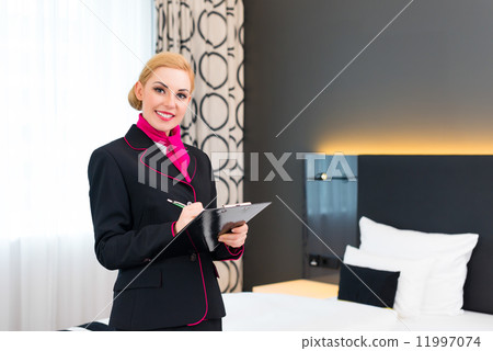 Housekeeper checking hotel room 11997074