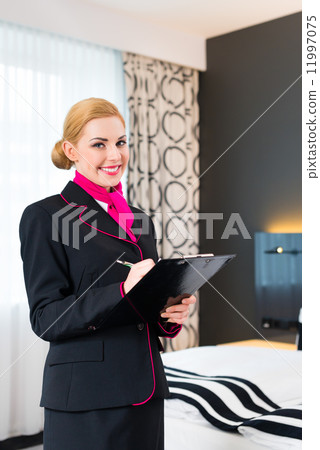 Housekeeper checking hotel room Housekeeper checking hotel room 11997075