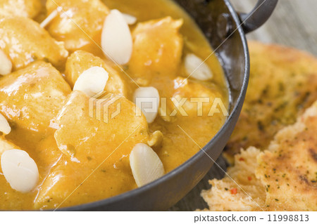 Chicken Korma - Chicken on a mildly spiced creamy sauce on a wooden background. Indian cuisine. 11998813