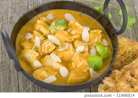 Chicken Korma - Chicken on a mildly spiced creamy sauce on a wooden background. Indian cuisine. Chicken Korma - Chicken on a mildly spiced creamy sauce on a wooden background. Indian cuisine. 11998814