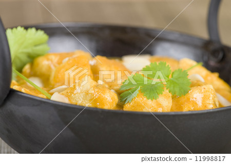 Chicken Korma - Chicken on a mildly spiced creamy sauce on a wooden background. Indian cuisine. Chicken Korma - Chicken on a mildly spiced creamy sauce on a wooden background. Indian cuisine. 11998817