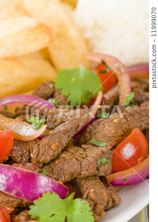 Lomo Saltado - Traditional Peruvian stir-fry with beef, red onions, tomatoes and fries Lomo Saltado - Traditional Peruvian stir-fry with beef, red onions, tomatoes and fries 11999070