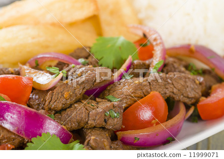 Lomo Saltado - Traditional Peruvian stir-fry with beef, red onions, tomatoes and fries Lomo Saltado - Traditional Peruvian stir-fry with beef, red onions, tomatoes and fries 11999071