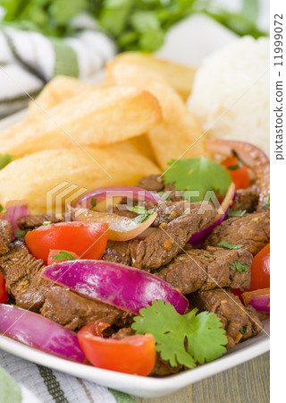 Lomo Saltado - Traditional Peruvian stir-fry with beef, red onions, tomatoes and fries Lomo Saltado - Traditional Peruvian stir-fry with beef, red onions, tomatoes and fries 11999072