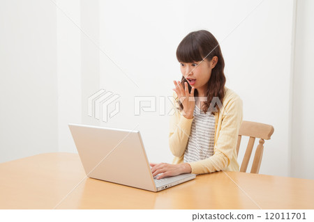 A woman who plays a personal computer A woman who plays a personal computer 12011701