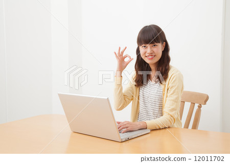 A woman who plays a personal computer A woman who plays a personal computer 12011702