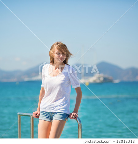Beautiful girl enjoying her vacation by the sea Beautiful girl enjoying her vacation by the sea 12012318