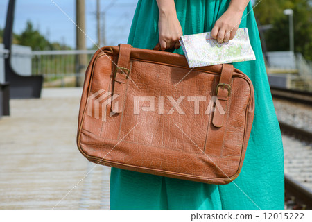 Girl in a holding a map and suitcase at station Girl in a holding a map and suitcase at station 12015222