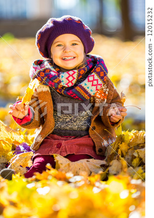 Little girl playing with autumn leaves 12015232