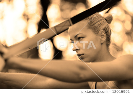 Training with fitness straps outdoors. 12016901