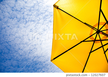 Yellow sun umbrella on a blue sky. 12027607