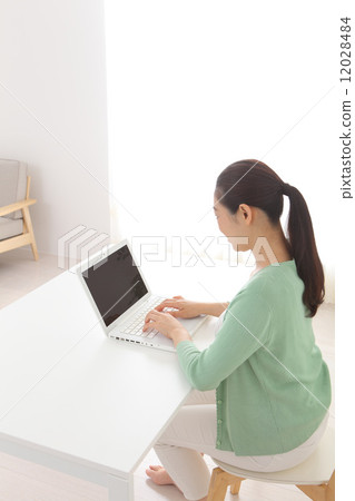 A woman using a personal computer A woman using a personal computer 12028484