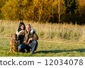 Cheerful couple with dog in autumn countryside 12034078
