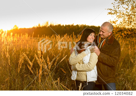 Couple hugging during autumn sunset countryside Couple hugging during autumn sunset countryside 12034082