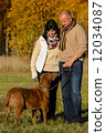 Couple with dog in sunny autumn park 12034087