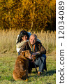 Cheerful couple with dog in autumn countryside 12034089
