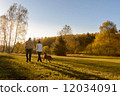 Couple walk dog autumn sunset countryside meadow 12034091