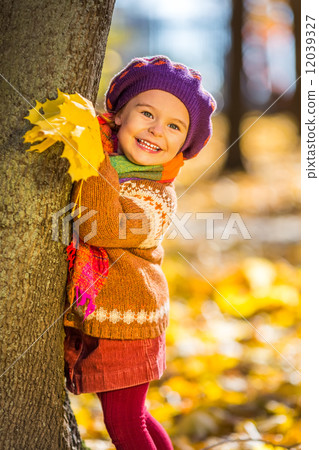 Happy little girl playing in the autumn park Happy little girl playing in the autumn park 12039327