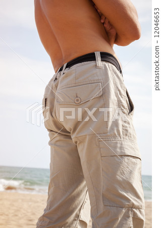 Back and legs of Young Caucasian man on the beach 12046653