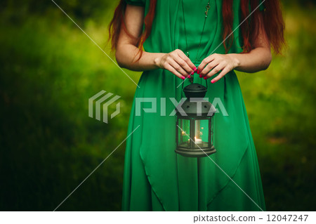 Woman holding lantern with candle Woman holding lantern with candle 12047247