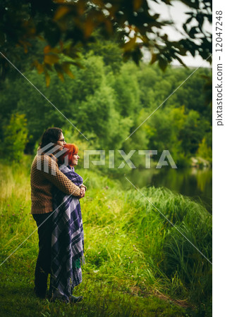 Young couple standing near water 12047248