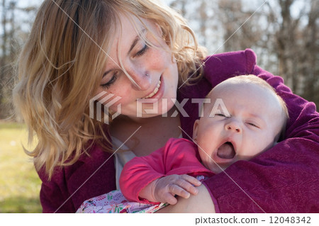Baby is yawning in mothers arms Baby is yawning in mothers arms 12048342