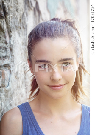 portrait of a beautiful teenager girl leaning against a wall 12051234