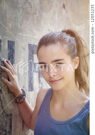 portrait of a beautiful teenager girl leaning against a wall 12051235