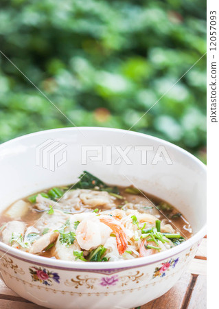 Thai spicy noodles soup with pork and shrimp on wood table 12057093