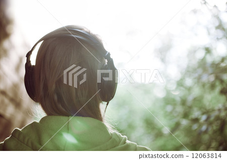 Woman in headphones against bright sunlight 12063814